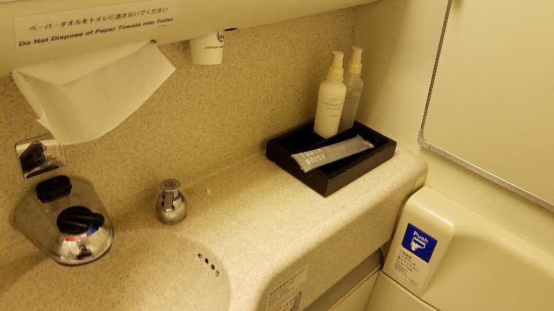 JALビジネスクラスのトイレにはうがい用の紙コップや歯ブラシが備え付けられています